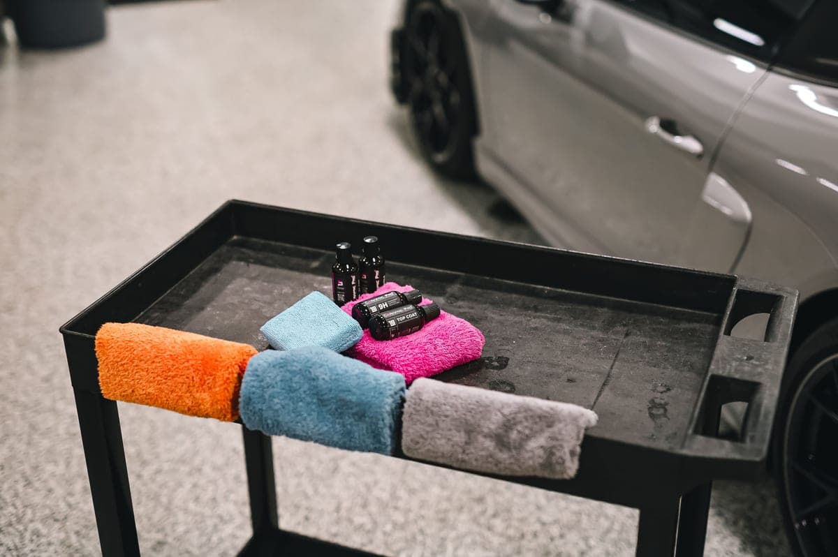 An arranged set of car-detailing bottles, pads and microfiber towels